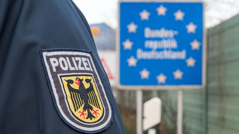 Wappen mit Aufschrift „Bundespolizei“ auf Uniformärmel genäht. Im Hintergrund ein Schild „Bundesrepublik Deutschland“. (Quelle: Bundespolizei) Wappen mit Aufschrift „Bundespolizei“ auf Uniformärmel genäht. Im Hintergrund ein Schild „Bundesrepublik Deutschland“.