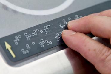 Finger einer Person auf einer Braillezeile.